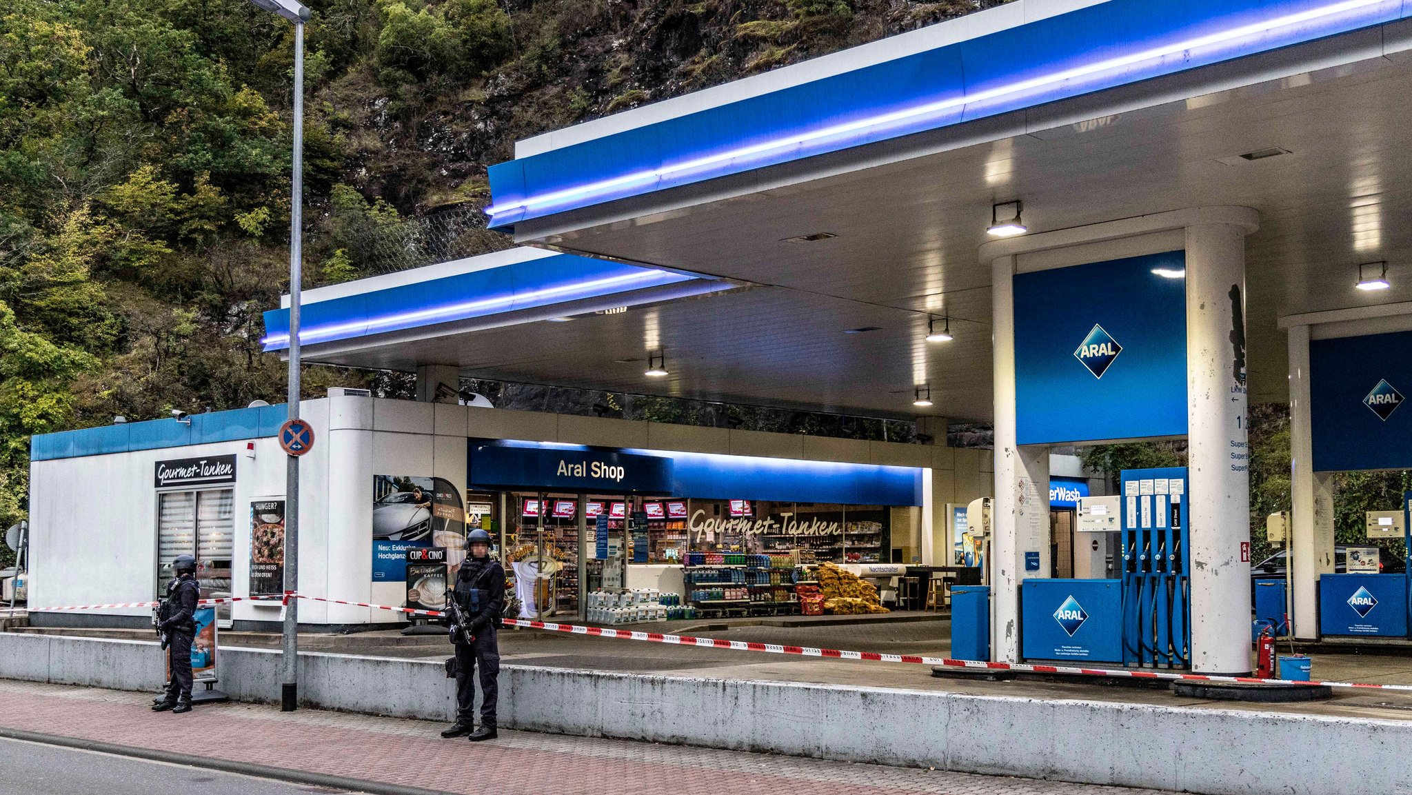 Polizisten sichern am frühen Morgen eine Tankstelle.