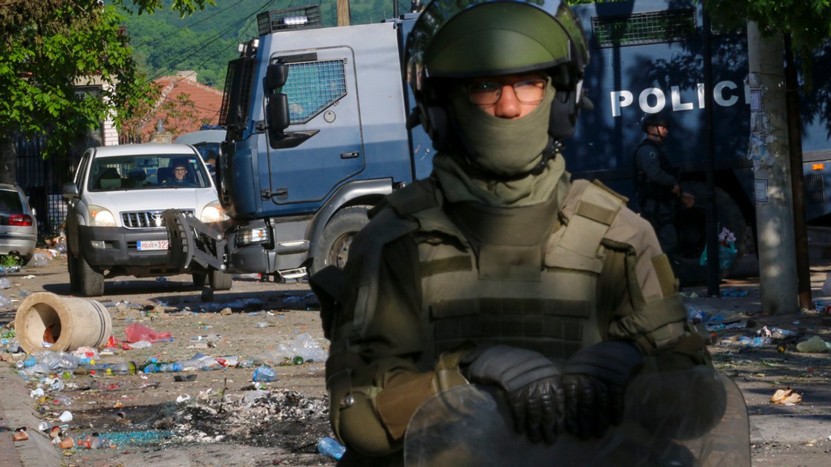 Ein KFOR-Soldat hält auf einer Straße Wache, im Hintergrund liegen Trümmerteile in der Stadt Zvecan im Norden des Kosovo