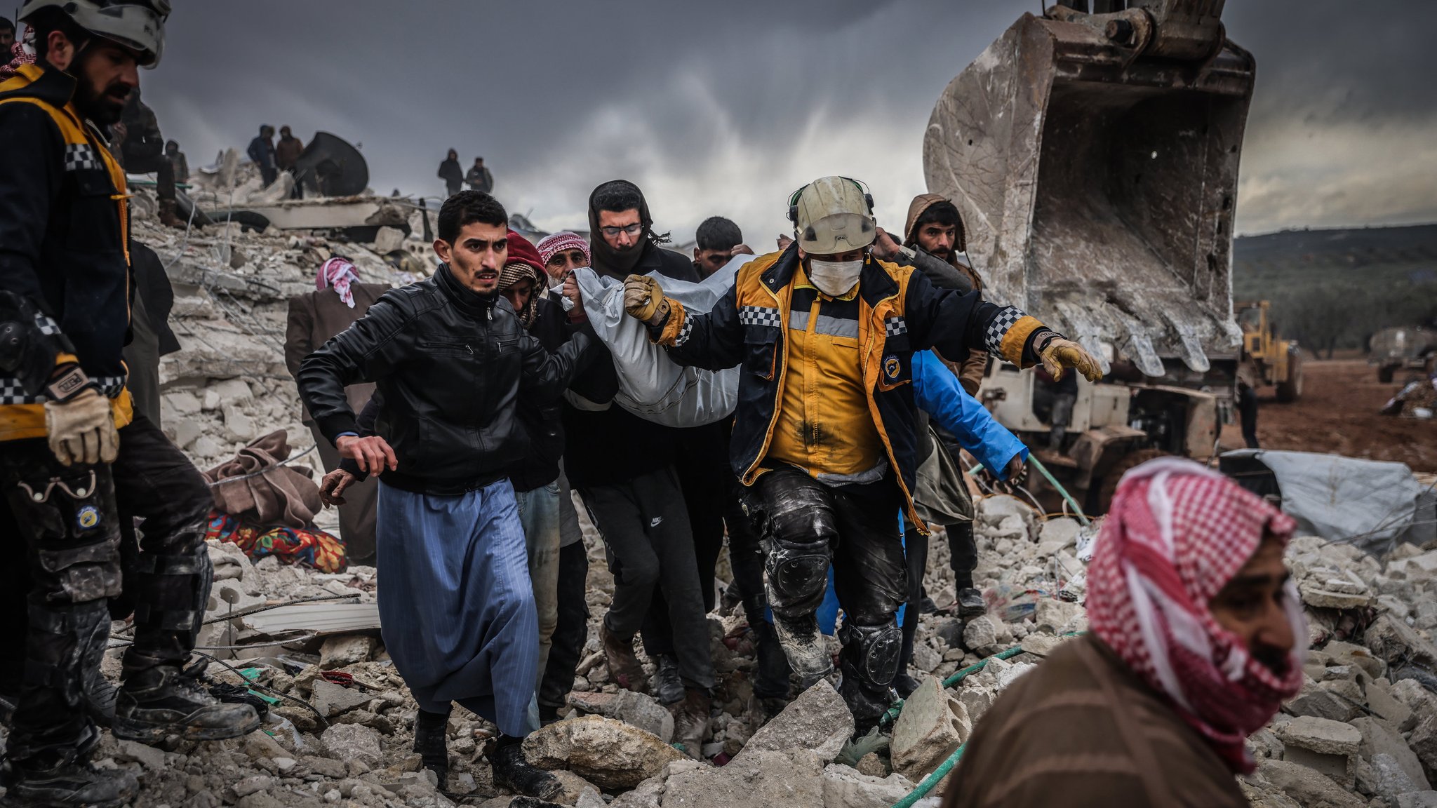 06.02.2023, Syrien, Harem: Zivilisten und Mitglieder des syrischen Zivilschutzes führen Such- und Rettungsmaßnahmesuchen in den Trümmern eines zerstörten Gebäudes durch. In der Türkei und in Syrien sind infolge der starken Erdbeben mindestens 2300 Menschen getötet worden. Foto: Anas Alkharboutli/dpa +++ dpa-Bildfunk +++