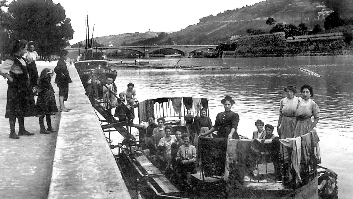 Historisches Foto: Frauen stehen auf einem Wasch-Schiff am Mainufer in Würzburg.