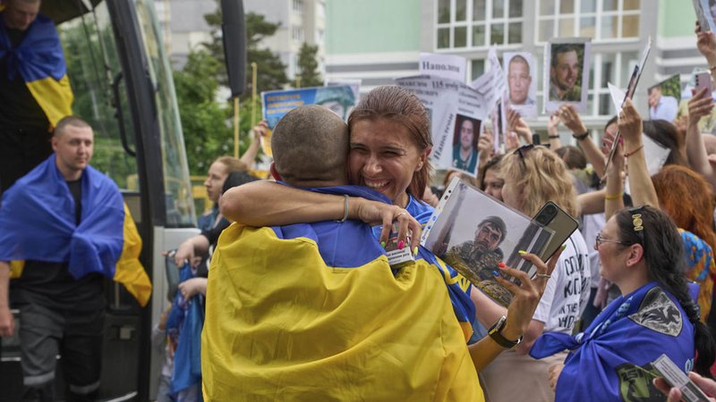 25.05.2025, Ukraine, Tschernihiw: Eine Frau umarmt einen Soldaten, der im Rahmen eines Kriegsgefangenenaustauschs zwischen Russland und der Ukraine am Sonntag, 25. Mai 2025 in der Region Tschernihiw aus der Gefangenschaft zurückgekehrt ist. Im Hintergrund zeigen Menschen Fotos von vermissten Soldaten. Russland und die Ukraine haben nach Angaben des russischen Verteidigungsministeriums ihren bisher größten Gefangenenaustausch abgeschlossen und jeweils weitere 303 Menschen freigelassen. Foto: Efrem Lukatsky/AP/dpa +++ dpa-Bildfunk +++ | Bild: dpa-Bildfunk/Efrem Lukatsky 25.05.2025, Ukraine, Tschernihiw: Eine Frau umarmt einen Soldaten, der im Rahmen eines Kriegsgefangenenaustauschs zwischen Russland und der Ukraine am Sonntag, 25. Mai 2025 in der Region Tschernihiw aus der Gefangenschaft zurückgekehrt ist. Im Hintergrund zeigen Menschen Fotos von vermissten Soldaten. Russland und die Ukraine haben nach Angaben des russischen Verteidigungsministeriums ihren bisher größten Gefangenenaustausch abgeschlossen und jeweils weitere 303 Menschen freigelassen. Foto: Efrem Lukatsky/AP/dpa +++ dpa-Bildfunk +++