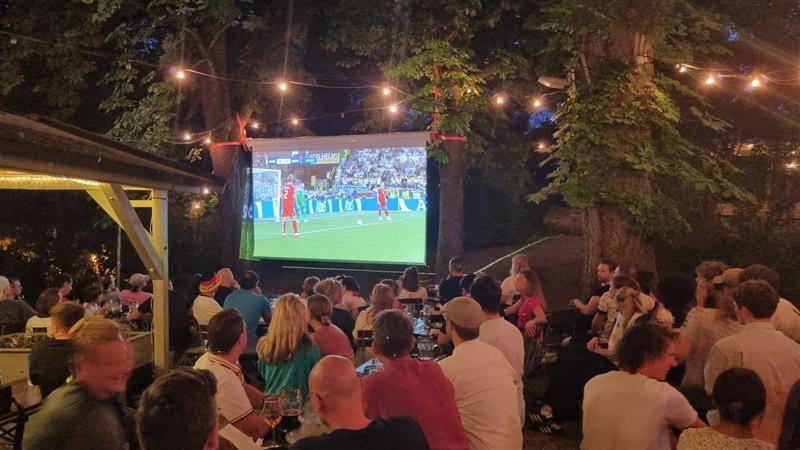 Eine große Leinwand in einem Biergarten. 