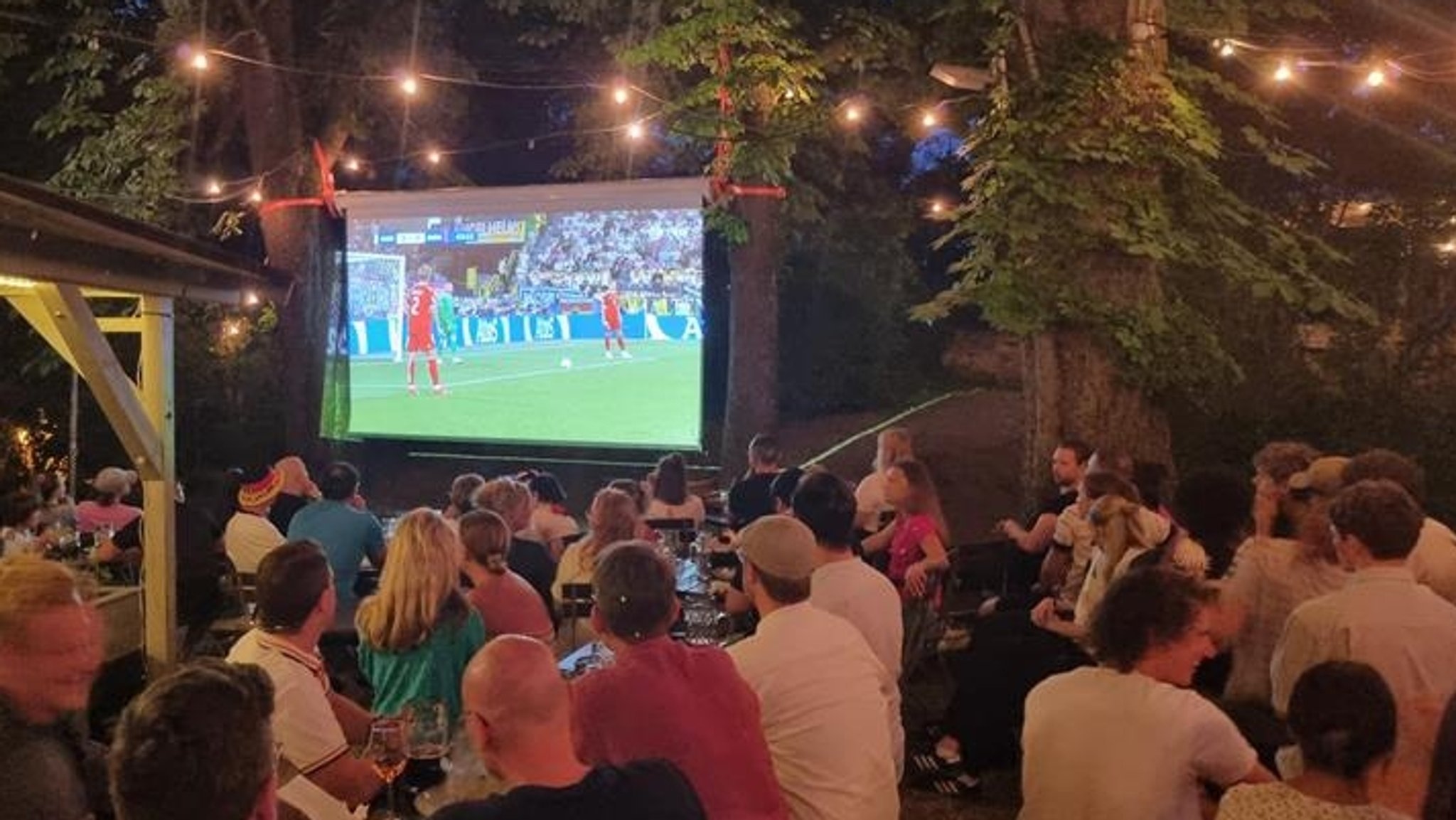 Eine große Leinwand in einem Biergarten. 