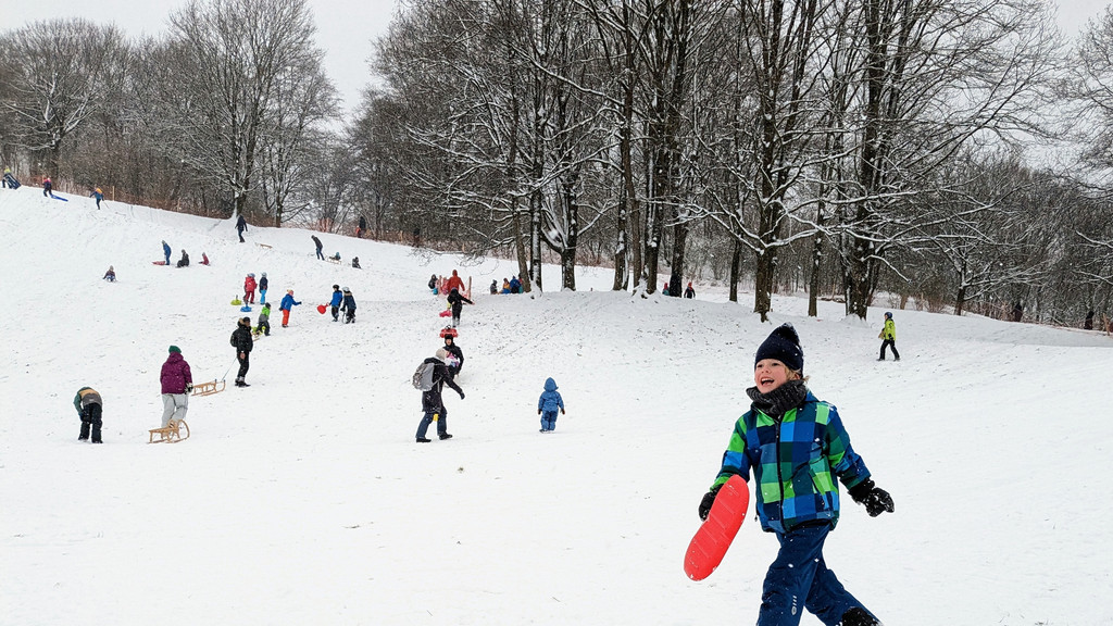 Kinder beim Schlittenfahren im Münchner Luitpoldpark