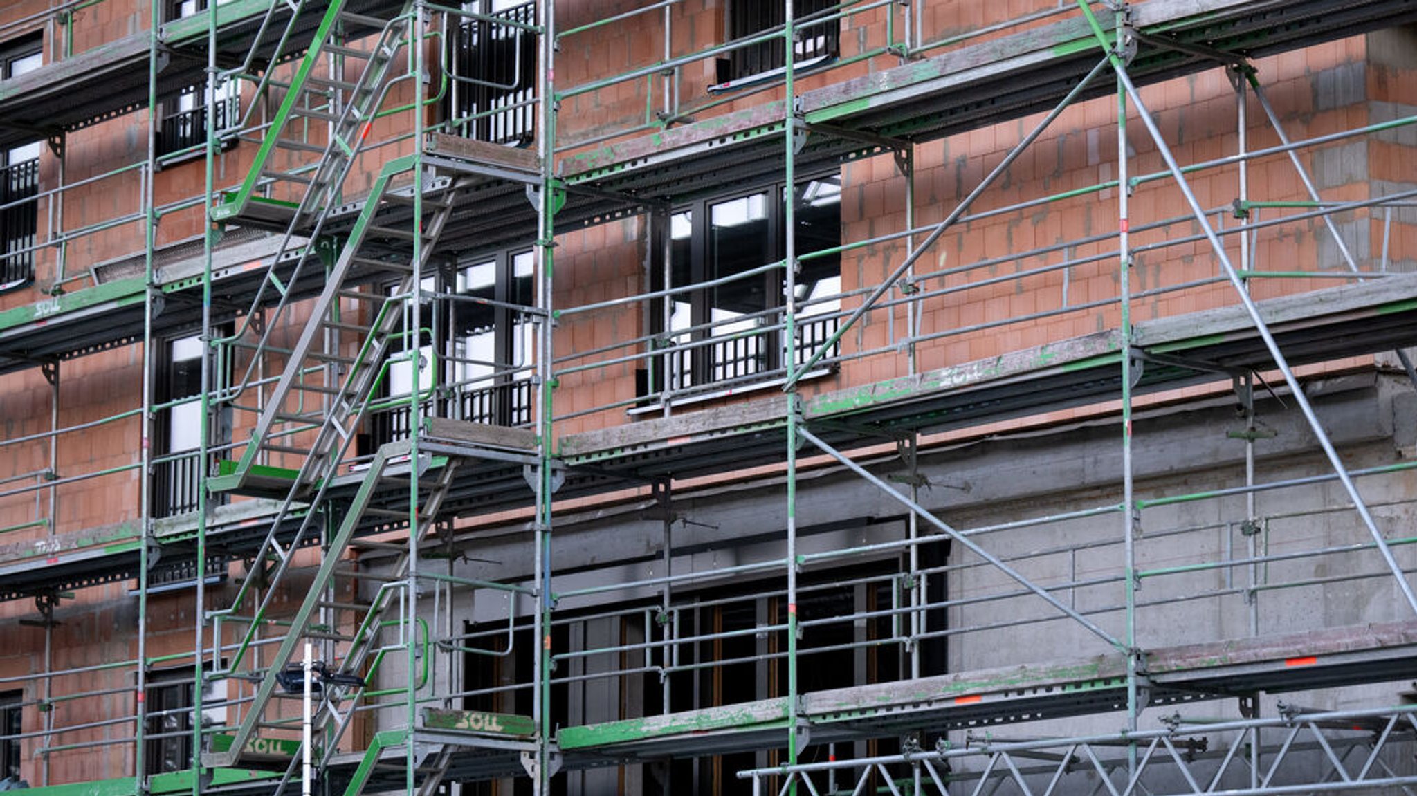 27.03.2024, Bayern, München: Ein Baugerüst steht auf einer Baustelle eines Neubaus. Wirtschaftsforschungsinstitute stellen am 27.03.2024 auf einer Pressekonferenz ihre Gemeinschaftsdiagnose für das Frühjahr 2024 vor. Foto: Sven Hoppe/dpa +++ dpa-Bildfunk +++