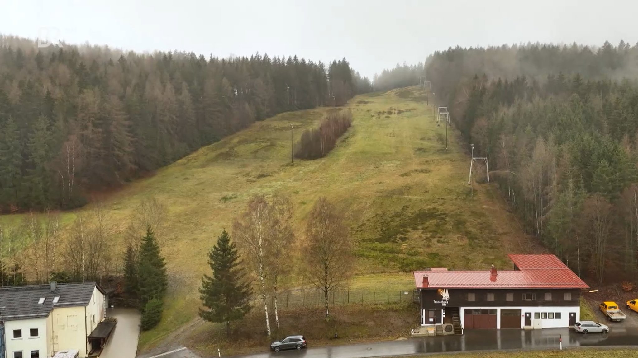 Luftaufnahme des Skihangs an dessen rechter Seite der Tannenberglift nach oben führt. 