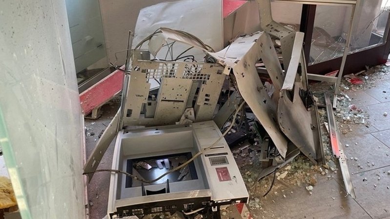 Teile eines gesprengten Geldautomaten liegen auf dem Boden, daneben auch Glasschreben.