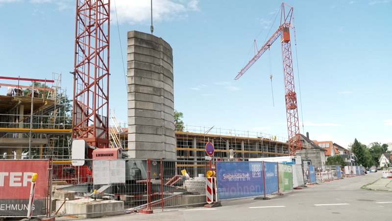 (Symbolbild) Wohnungsbauprojekt in der Bergermühlstraße in Memmingen: Kräne stehen vor einem umzäunten Rohbau. | Bild: BR / Florian Regensburger (Symbolbild) Wohnungsbauprojekt in der Bergermühlstraße in Memmingen: Kräne stehen vor einem umzäunten Rohbau.