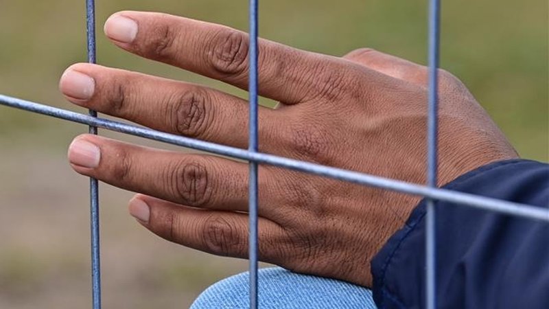 Die Hand eines Flüchtlings an einem Zaun der Zentralen Erstaufnahmeeinrichtung für Asylbewerber (ZABH) des Landes Brandenburg. | Bild: pictore alliance/dpa/dpa-Zentralbild/ Patrick Pleul Die Hand eines Flüchtlings an einem Zaun der Zentralen Erstaufnahmeeinrichtung für Asylbewerber (ZABH) des Landes Brandenburg.