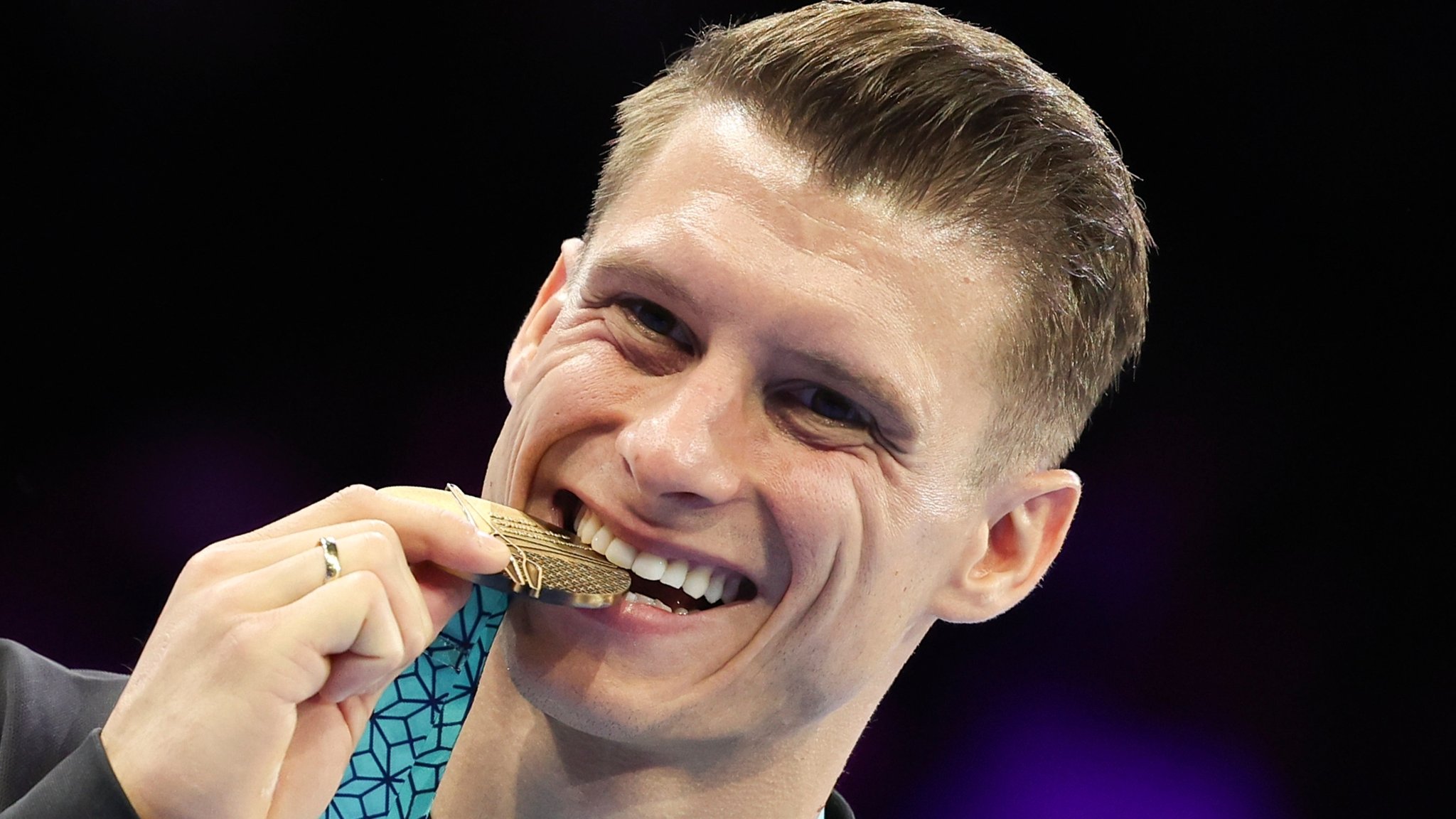 08.10.2023, Belgien, Antwerpen: Turnen: Weltmeisterschaft, Barren, Männer: Lukas Dauser aus Deutschland beißt auf seine Goldmedaille. Dauser hat als erster deutscher Turner seit 16 Jahren WM-Gold gewonnen. 