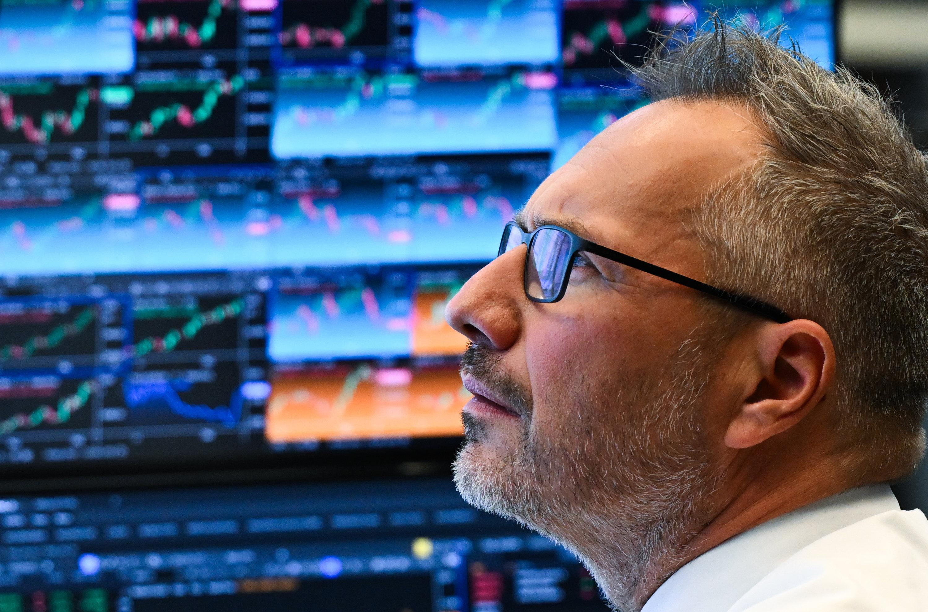 Ein Börsenhändler sitzt im Handelssaal der Frankfurter Wertpapierbörse vor seinen Monitoren.