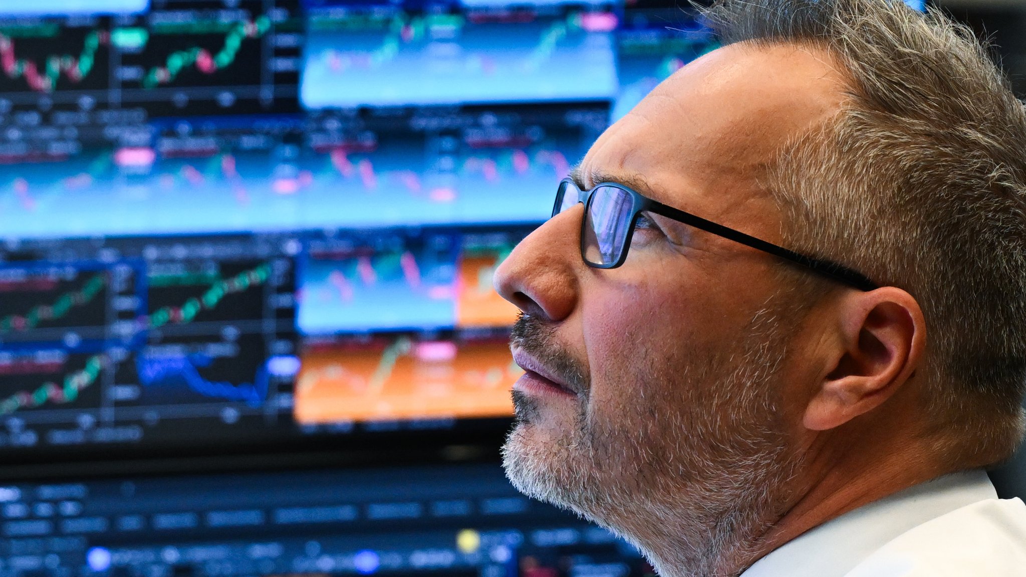 Ein Börsenhändler sitzt im Handelssaal der Frankfurter Wertpapierbörse vor seinen Monitoren.