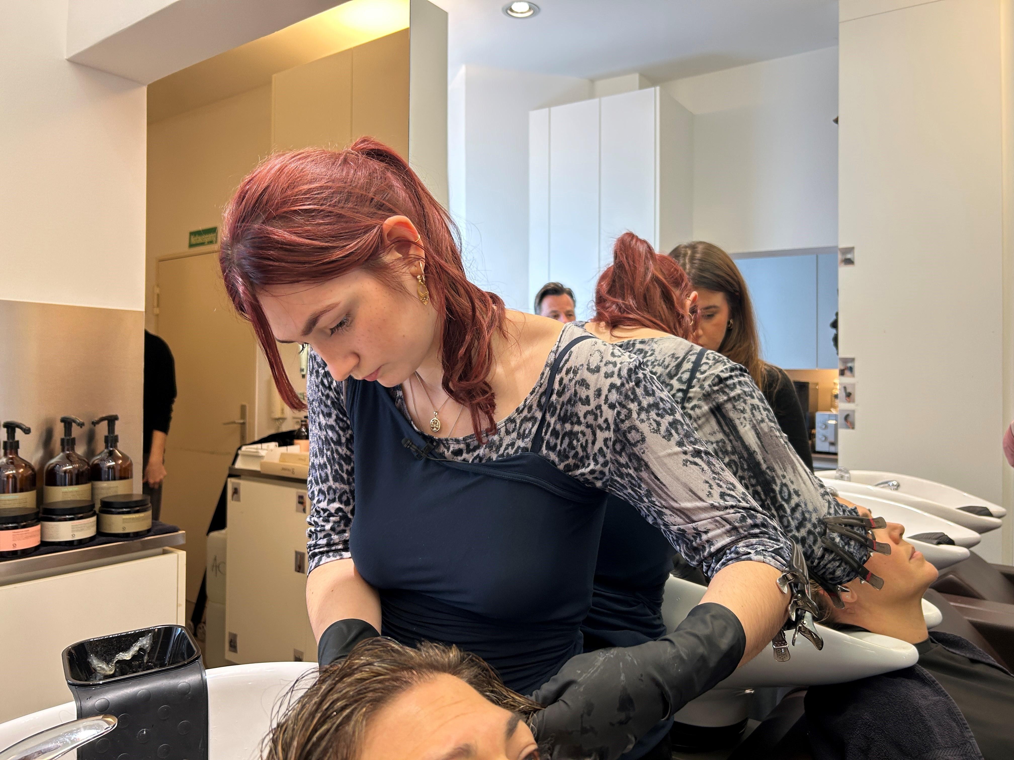 Zu sehen ist Azubi Emma, während sie einer Kundin Strähnchen färbt. 