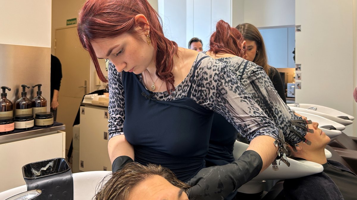 Zu sehen ist Azubi Emma, während sie einer Kundin Strähnchen färbt. | Bild: BR/Lucia Hundbiß Zu sehen ist Azubi Emma, während sie einer Kundin Strähnchen färbt.
