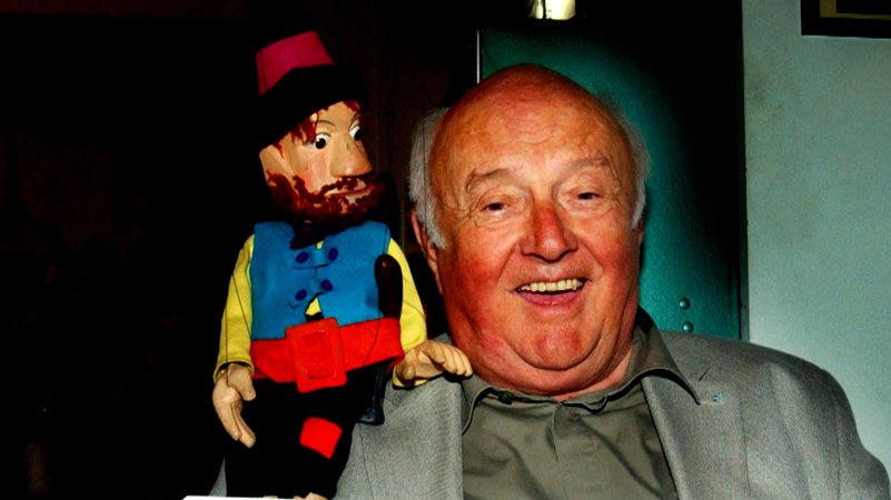 Otfried Preußler mit einer Räuber-Hotzenplotz-Marionette auf seiner Schulter.