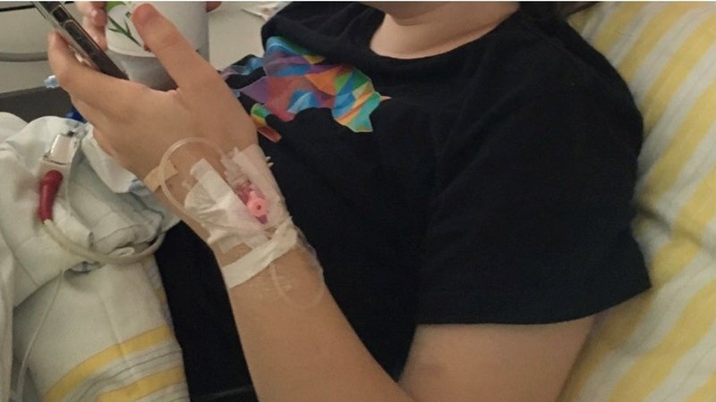 Eine junge Frau liegt in einem Krankenhausbett, nachdem ihr Körper nach der Corona-Impfung heftige Reaktionen zeigte.