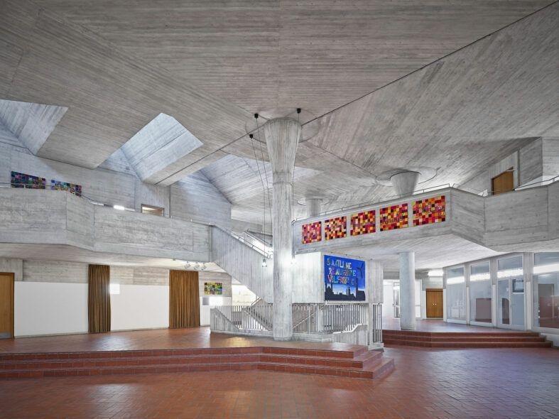 Aus der Aula einer Schule führen Treppen nach oben.