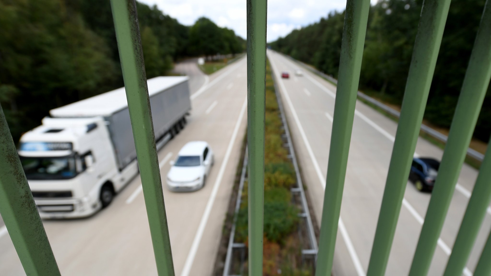 Symbolbild: Blick durchs Brückengelände auf eine Autobahn