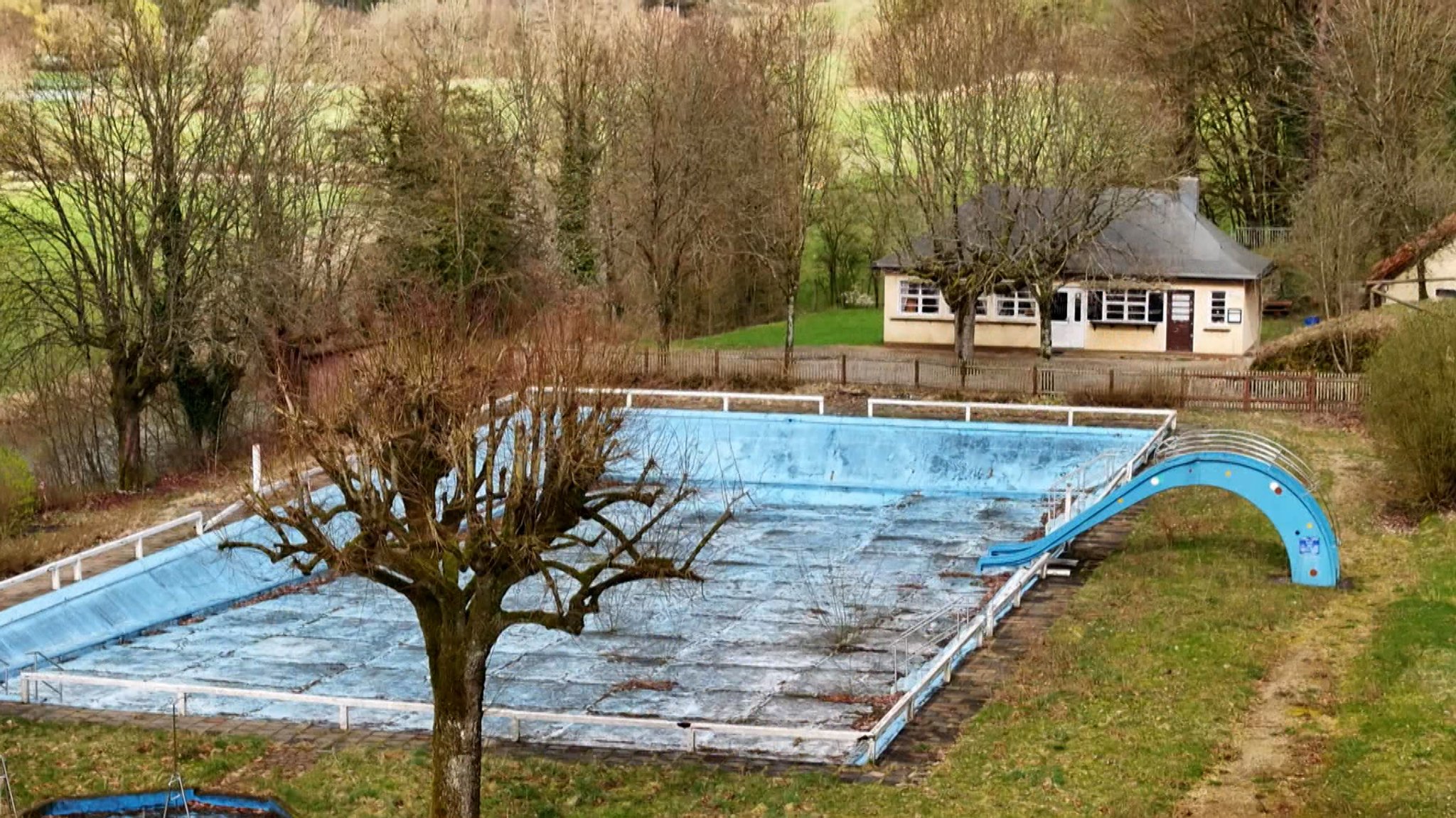 Ein leeres Freibad, dessen Becken nicht mit Wasser gefüllt ist. 