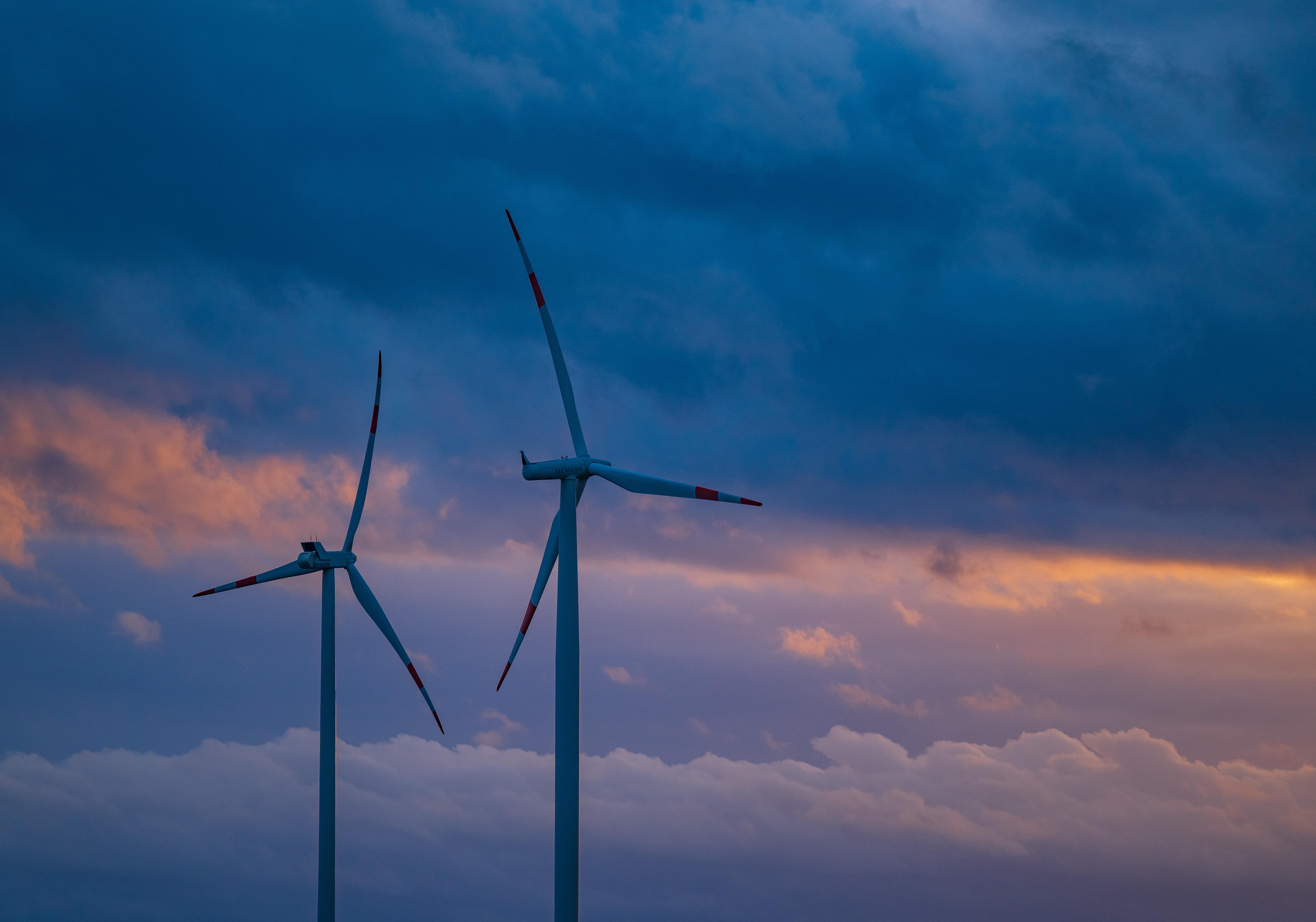 Zwei Windräder vor einem Wolkenhimmel
