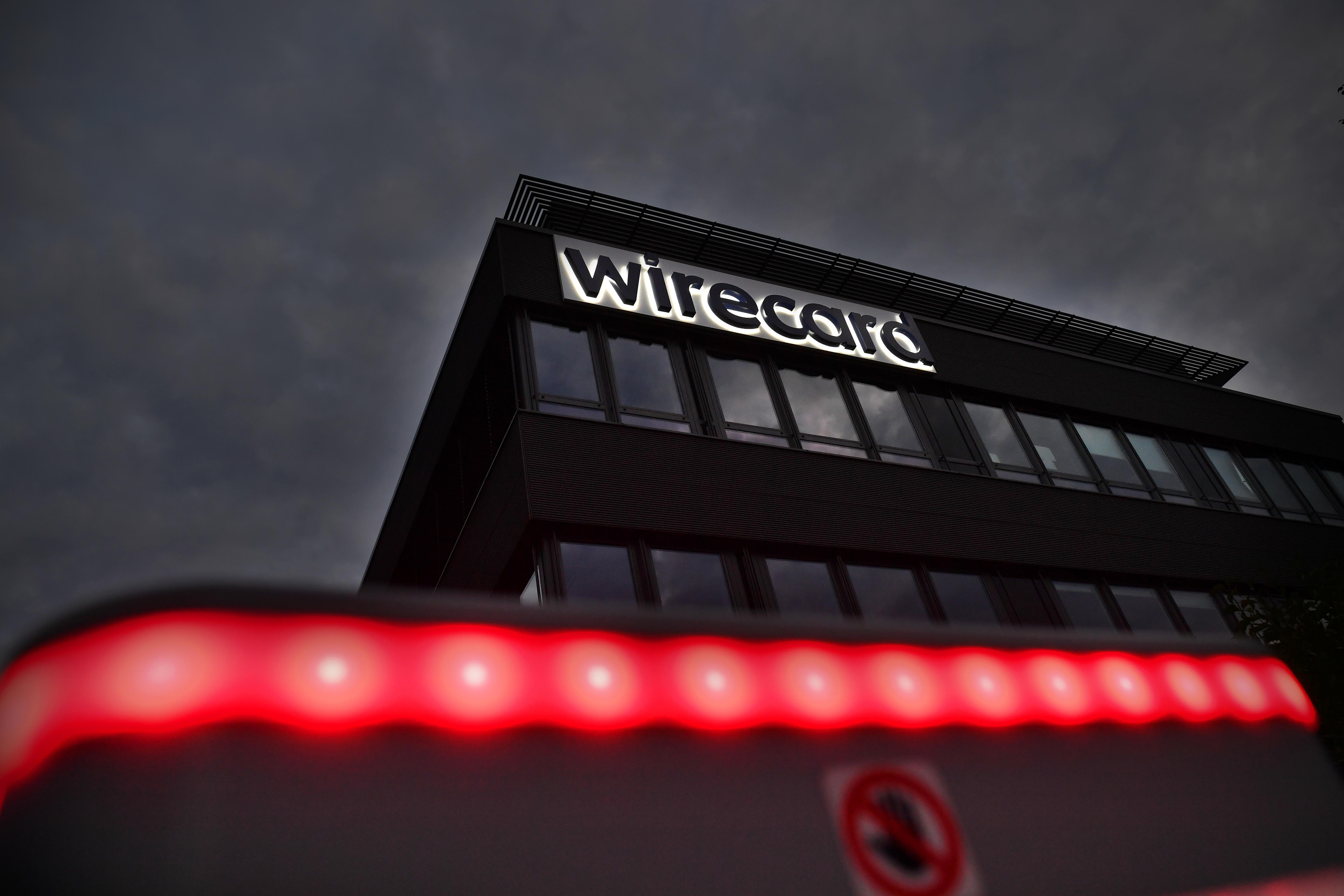 Der Schriftzug Wirecard leuchtet an der Fassasde des Firmensitzes. Darunter ein rotes Lichtband und ein Stoppzeichen. | Bild:pa/dpa/Sven Simon