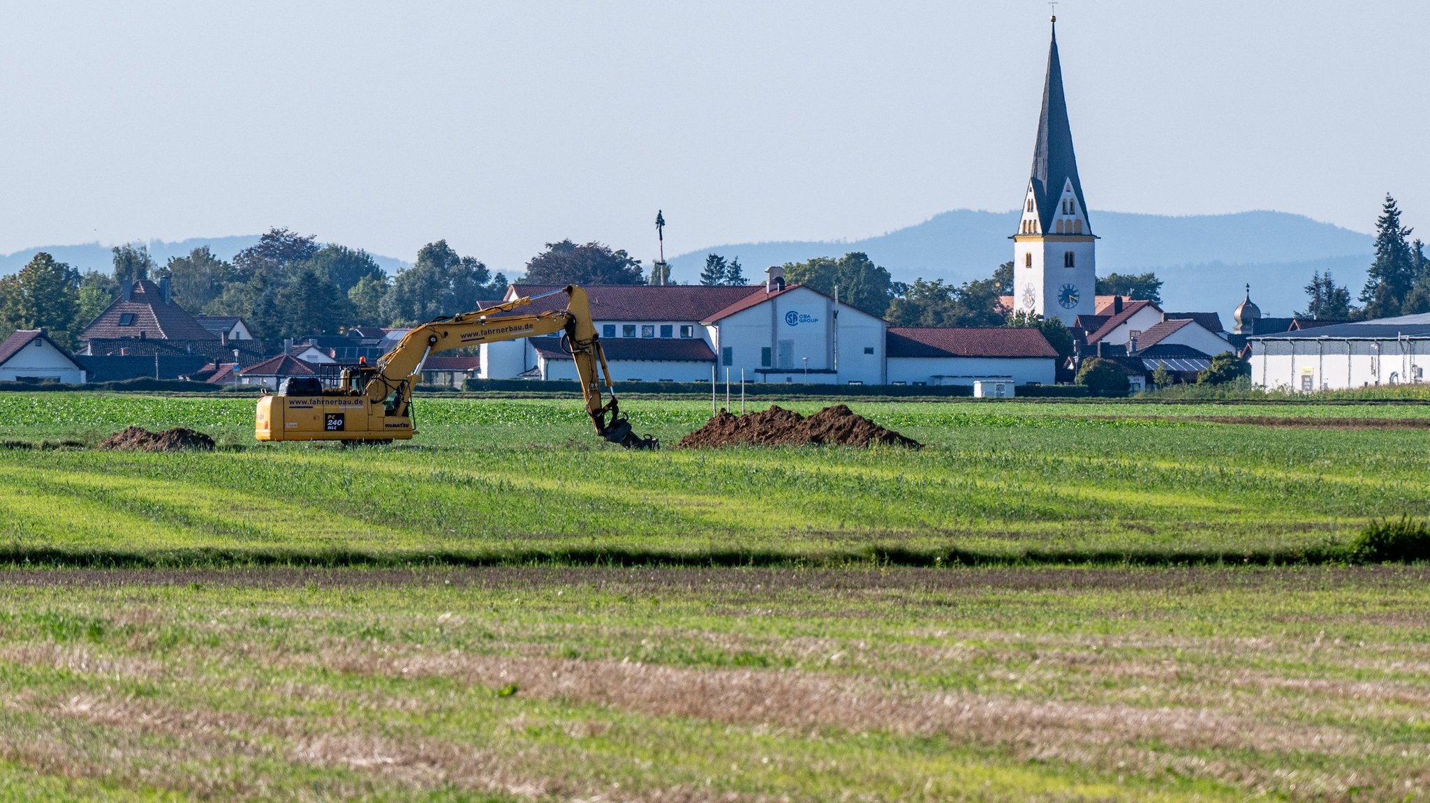 ARCHIV - 15.09.2023, Bayern, Straßkirchen: Ein Feld zwischen Irlbach und Straßkirchen, im Hintergrund die Pfarrkirche St. Stephanus in Straßkirchen. BMW will 40 Kilometer nördlich seines größten europäischen Autowerks Dingolfing eine Batteriefabrik errichten. (zu: dpa "Geplante BMW-Batteriefabrik: Am Sonntag entscheiden die Bürger") Foto: Armin Weigel/dpa +++ dpa-Bildfunk +++