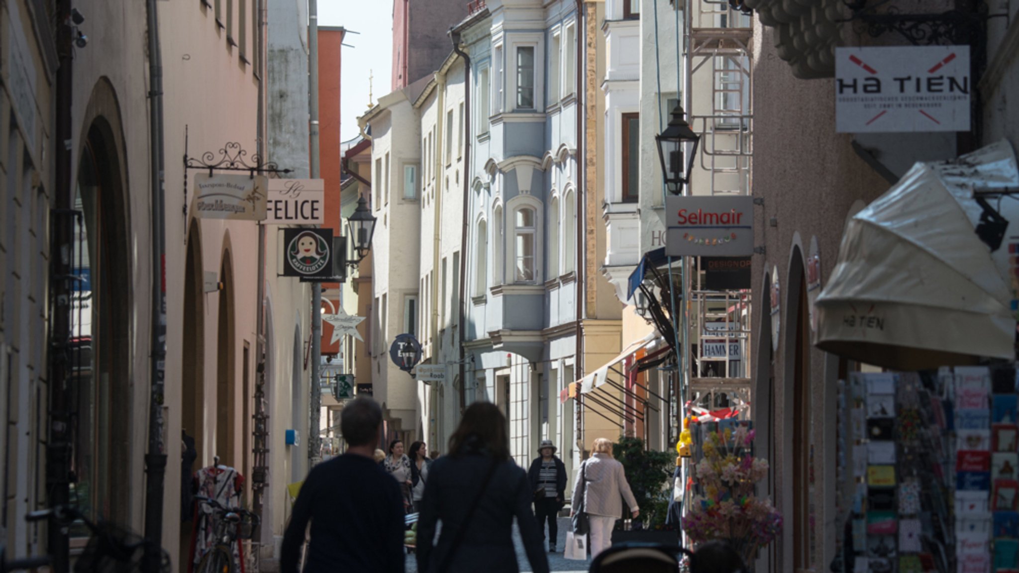 Menschen spazieren durch eine Gasse in Regensburg