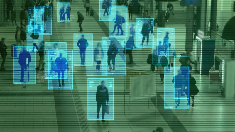 Eine Menschenmenge in einem öffentlichen Raum, überwacht durch KI-gestützte Gesichtserkennung, die Personen in digitalen Rahmen erfasst. | Bild: stock.adobe.com/AlinStock Eine Menschenmenge in einem öffentlichen Raum, überwacht durch KI-gestützte Gesichtserkennung, die Personen in digitalen Rahmen erfasst.