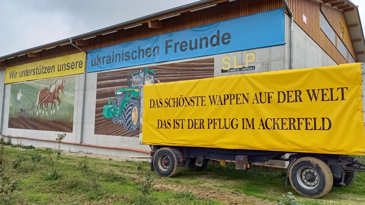 Der umstrittene Spruch auf einem Wandbild in Tapfheim ist abgehängt, taucht dafür aber jetzt auf einem Lkw-Anhänger auf.
