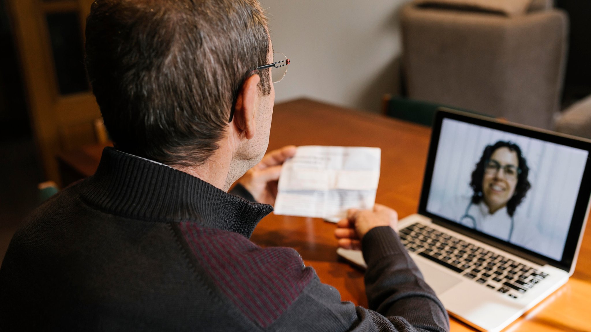 Ein Mann sitzt vor einem Notebook, auf dessen Bildschirm eine Ärztin zu sehen ist | Bild: picture alliance / Westend61 | Xavier Lorenzo Ein Mann sitzt vor einem Notebook, auf dessen Bildschirm eine Ärztin zu sehen ist