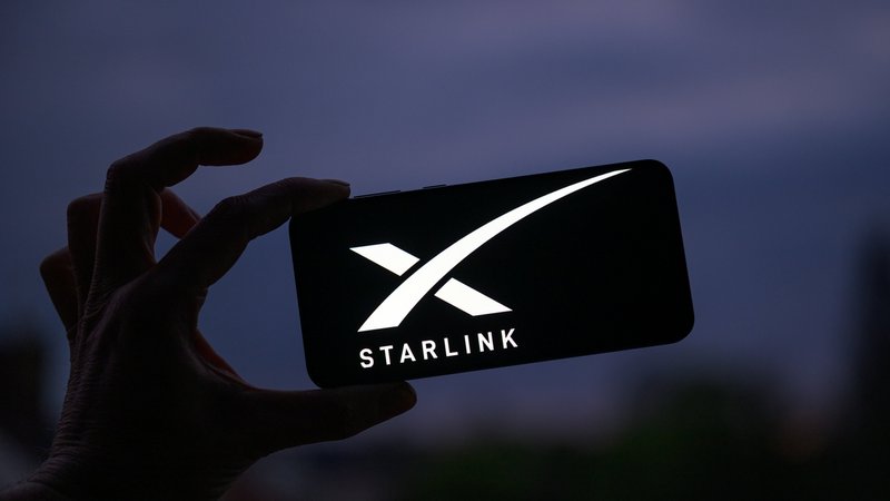 Hand hält Smartphone mit SpaceX Starlink logo | Bild: picture alliance / NurPhoto | Jonathan Raa Hand hält Smartphone mit SpaceX Starlink logo