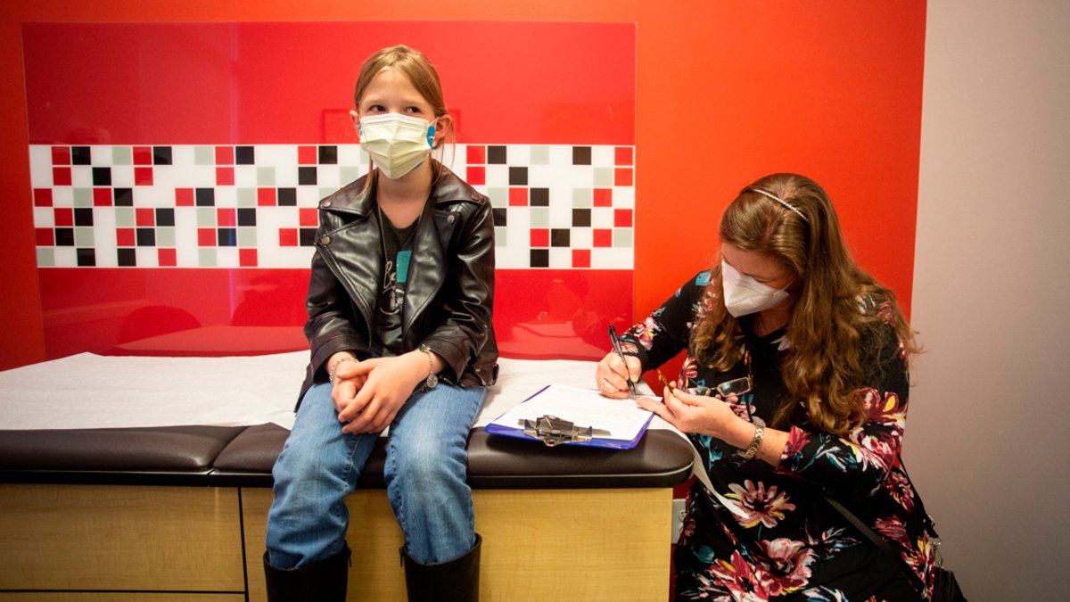 Eine 10-Jährige in den USA sitzt neben ihrer Mutter in einer Kinderarztpraxis und wartet darauf, gegen das Coronavirus geimpft zu werden. Die USA haben damit begonnen, Kinder im Grundschulalter gegen das Coronavirus zu impfen.