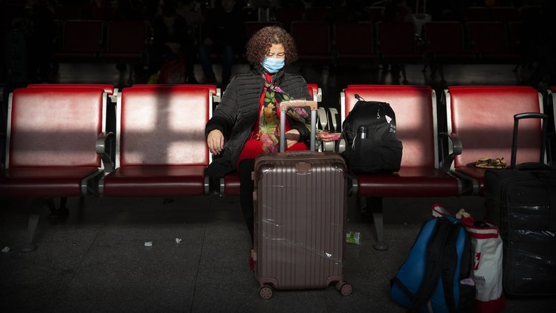 Eine Reisende trägt Mundschutz als Schutzmaßnahme gegen die Verbreitung des Corona-Virus, während sie in einem Warteraum am Pekinger Westbahnhof sitzt.