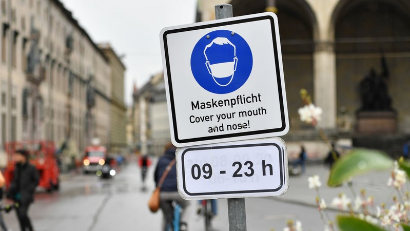 Schild mit Hinweis auf Maskenpflicht am Odeonsplatz in München.