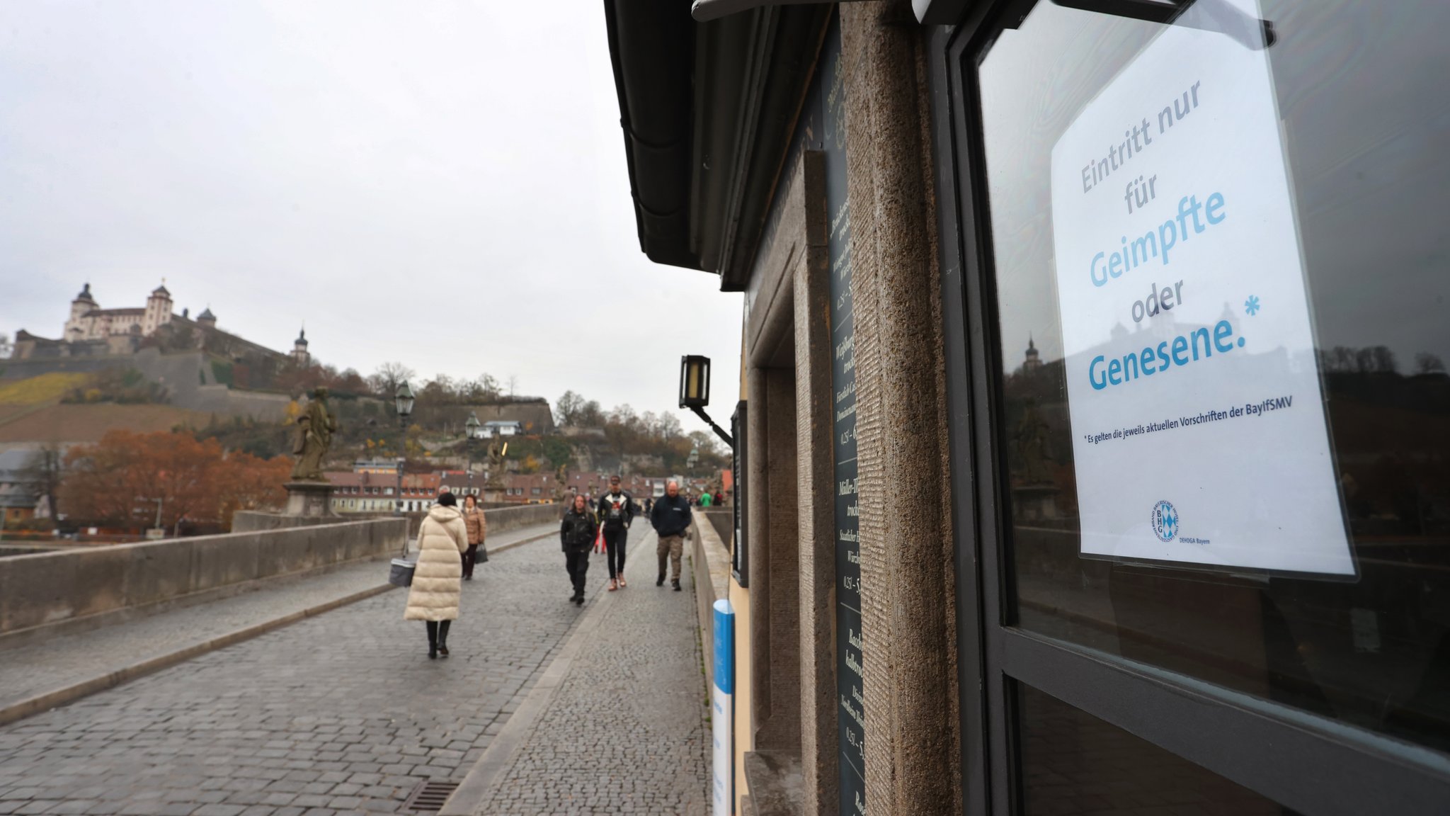 Würzburg: An der Fensterscheibe eines Restaurants auf der alten Mainbrücke wird auf Einhaltung der 2G-Regel hingewiesen. 