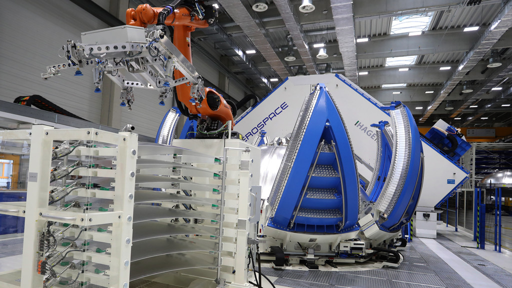 Ein Tankteil einer Ariane 6 Rakete steht in einer Produktionshalle des Raumfahrtunternehmens MT Aerospace in einem Schweißgerät (Archivbild).