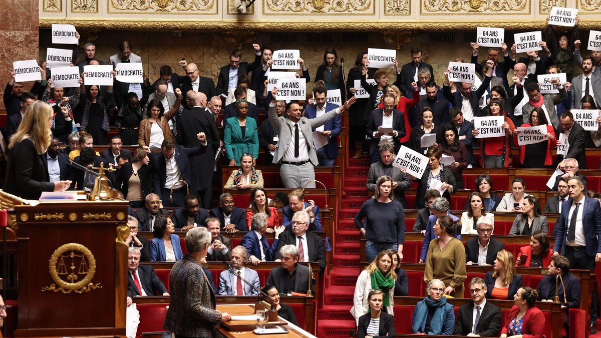 Gegner der Rentenreform von Präsident Macron halten Transparente im französischen Parlament hoch.