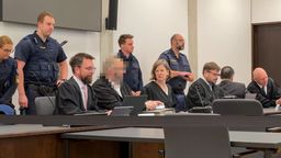 Die Angeklagten mit ihren Verteidigern, im Hintergrund Justizbeamte. | Bild:BR24/Henry Lai