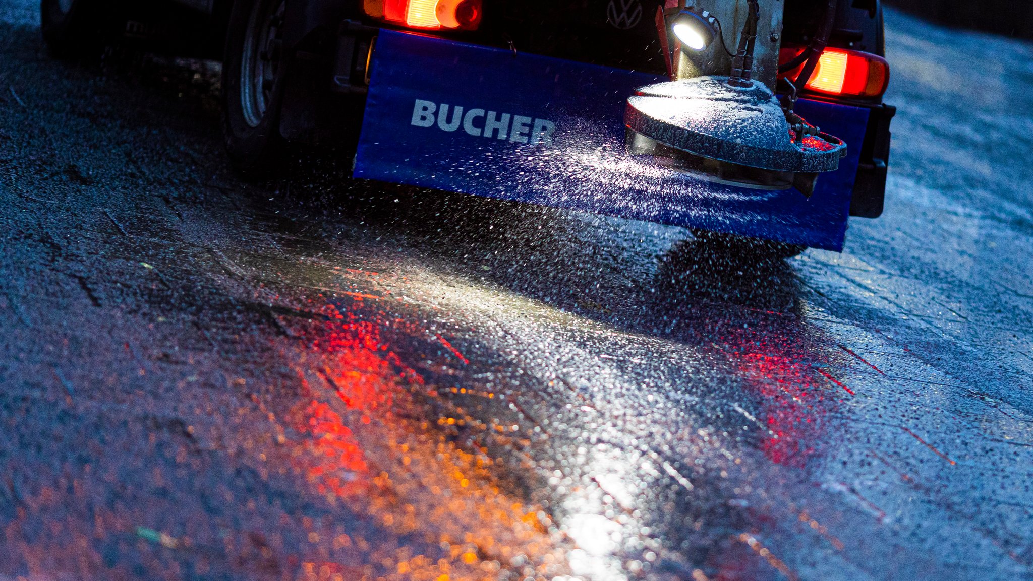 Ein Streufahrzeug verteilt Streumittel auf eisigem Boden