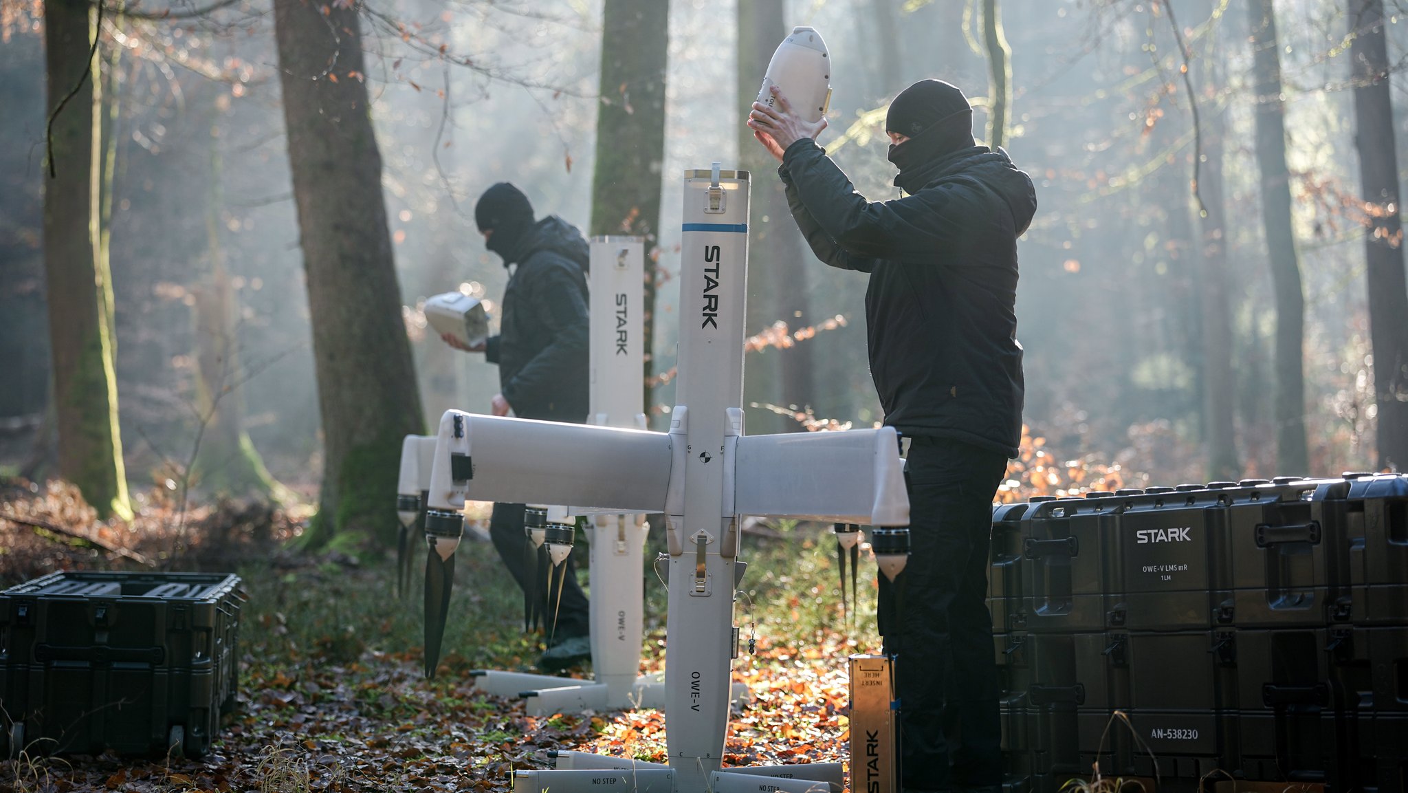 Zwei Männer stehe vor einer Drohne und bauen diese zusammen.