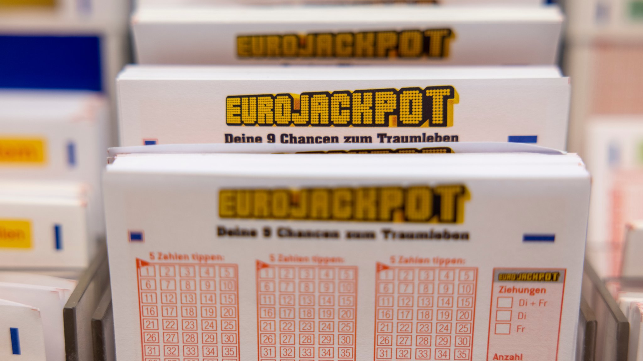 Eurojackpot Spielscheine stehen in einem Regal in einer Lotto-Annahmestelle. 