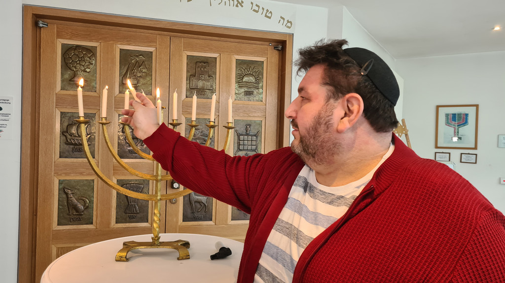 Der Jugendleiter der Israelitischen Kulturgemeinde in Würzburg Alexander Shif beim Entzünden Kerzenleuchters, der Chanukkia. | Bild: Conny Kleinschroth / BR Der Jugendleiter der Israelitischen Kulturgemeinde in Würzburg Alexander Shif beim Entzünden Kerzenleuchters, der Chanukkia.