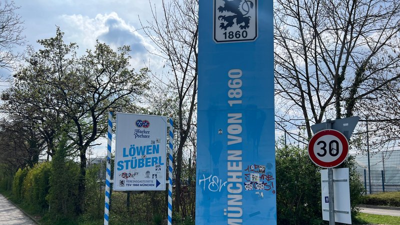 Zwei Schilder stehen am Eingang zum Vereinsgelände des TSV 1860 München. | Bild: BR/Julia Binder Zwei Schilder stehen am Eingang zum Vereinsgelände des TSV 1860 München.