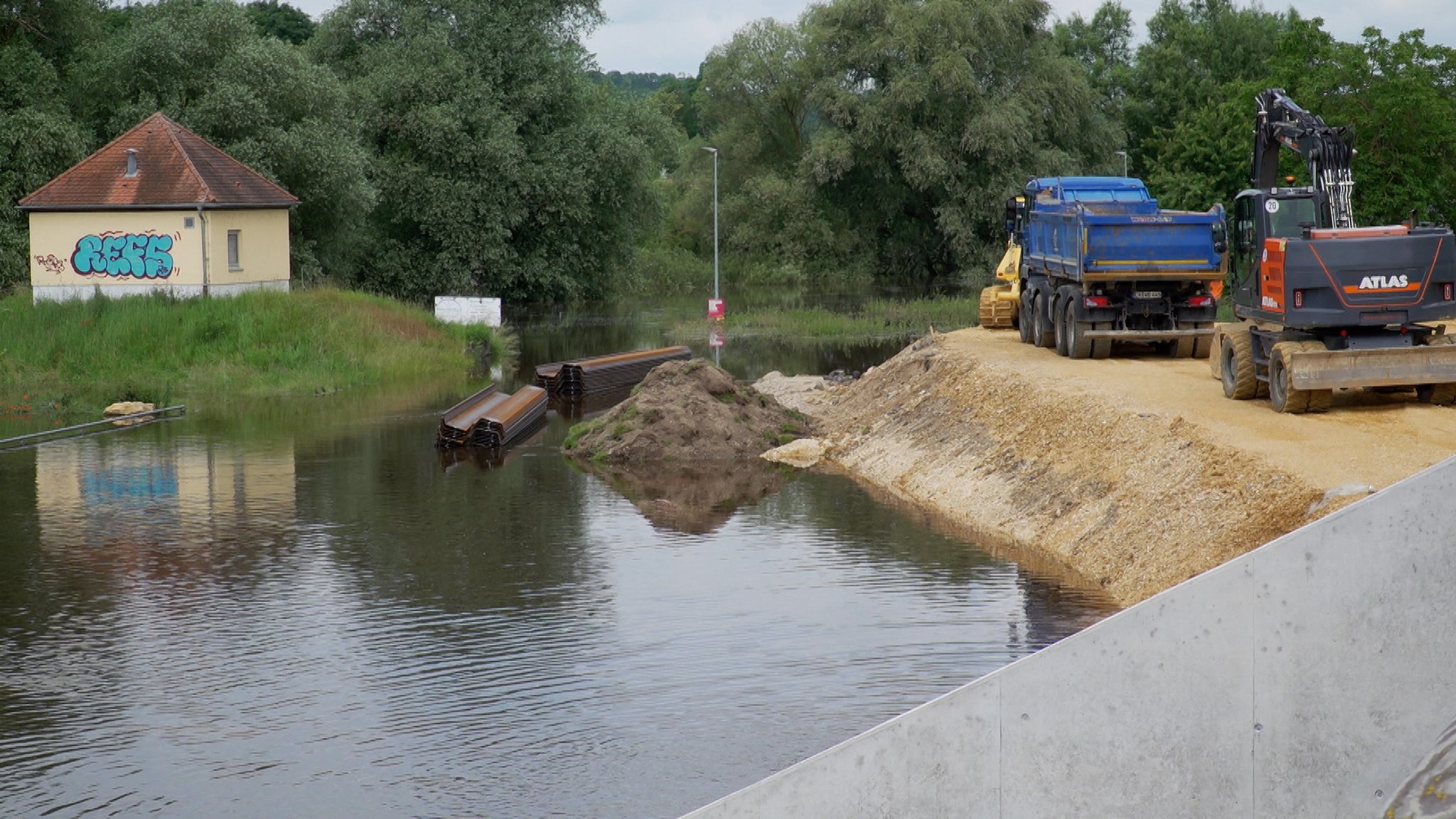 Baufahrzeuge an einem nicht fertiggestellten Hochwasserschutz