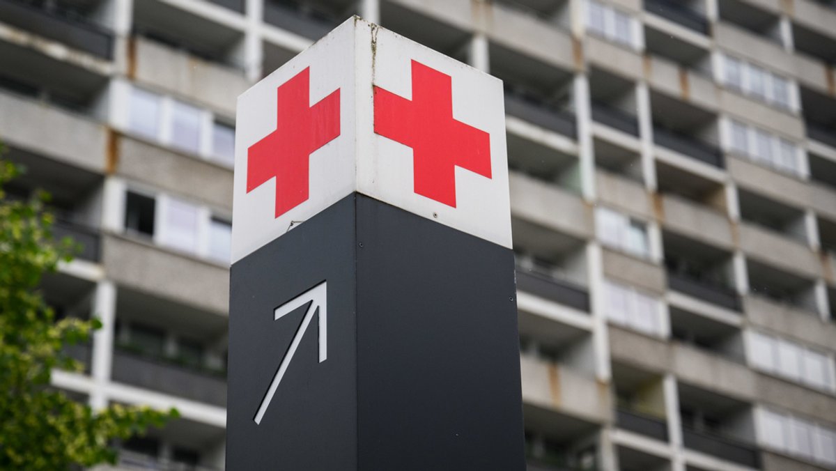Symbolbild: Ein Schild mit einem roten Kreuz weist den Weg zur Notaufnahme eines Krankenhauses. 