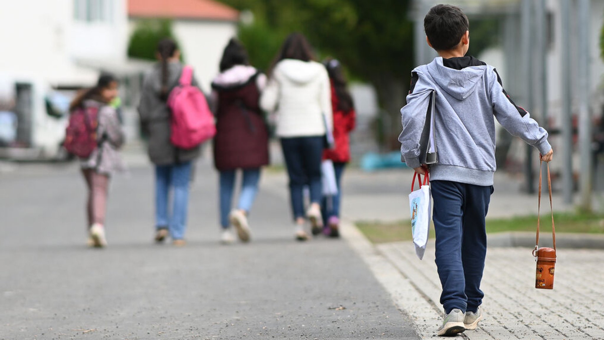 Archivbild: Flüchtlinge gehen in der Landesaufnahmebehörde Niedersachsen am Standort Grenzdurchgangslager Friedland an Unterkünften vorbei.