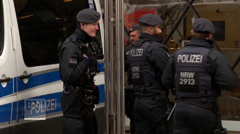 Polizeibeamte an einem Polizeiwagen. | Bild: BR Polizeibeamte an einem Polizeiwagen.