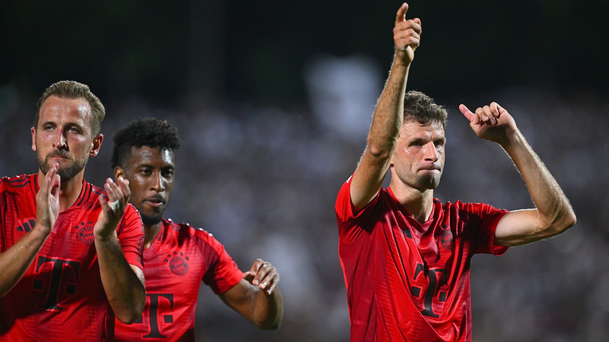 16.08.2024, Baden-Württemberg, Ulm: Fußball, DFB-Pokal, 1. Runde, SSV Ulm 1846 - Bayern München, Donaustadion: Münchens Thomas Müller (r), Münchens Kingsley Coman (M) und Münchens Harry Kane jubeln nach dem Spiel. WICHTIGER HINWEIS: Gemäß den Vorgaben der DFL Deutsche Fußball Liga bzw. des DFB Deutscher Fußball-Bund ist es untersagt, in dem Stadion und/oder vom Spiel angefertigte Fotoaufnahmen in Form von Sequenzbildern und/oder videoähnlichen Fotostrecken zu verwerten bzw. verwerten zu lassen. 