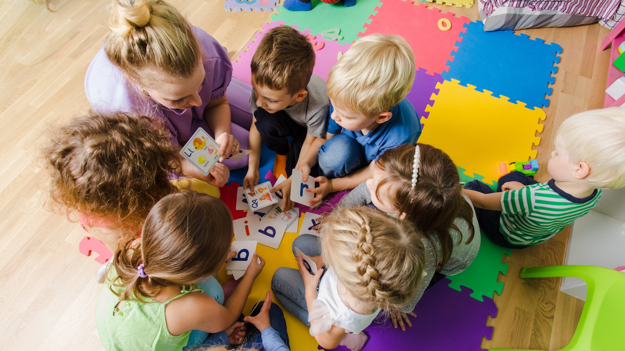 Eine Erzieherin mit einer Gruppe Kinder in einer Kindertagesstätte.