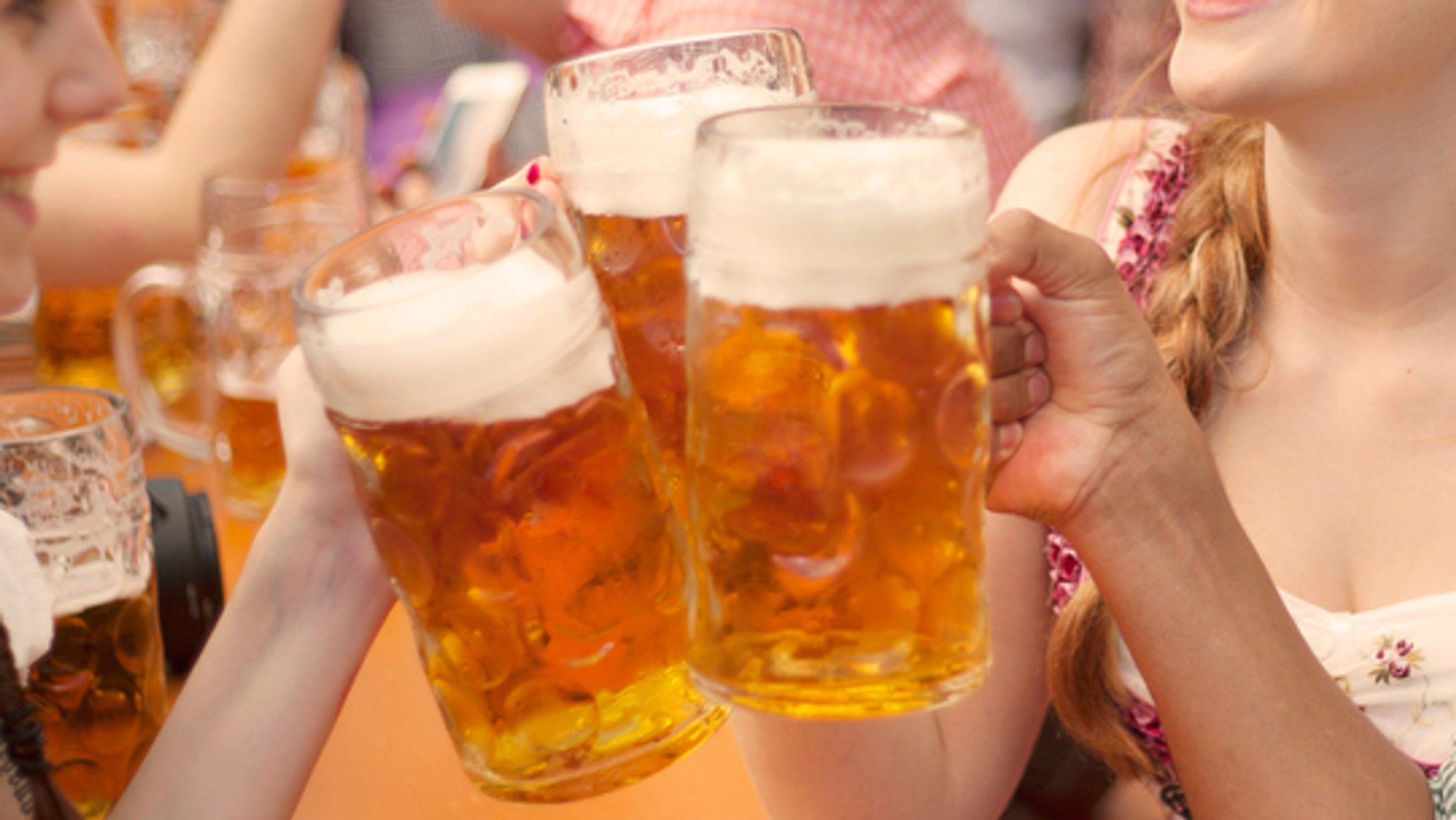 Gäste stoßen auf dem Oktoberfest mit Bier an